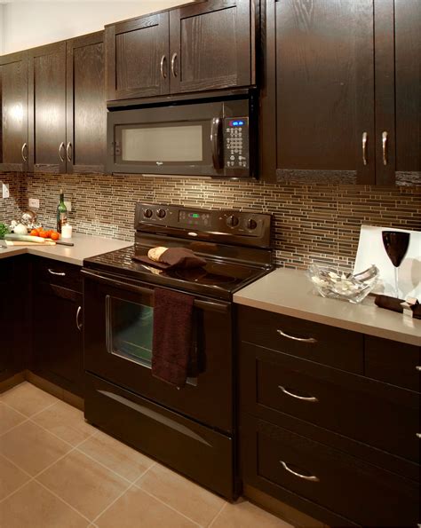 dark cabinets with stainless steel backsplash|light countertops with dark cabinets.